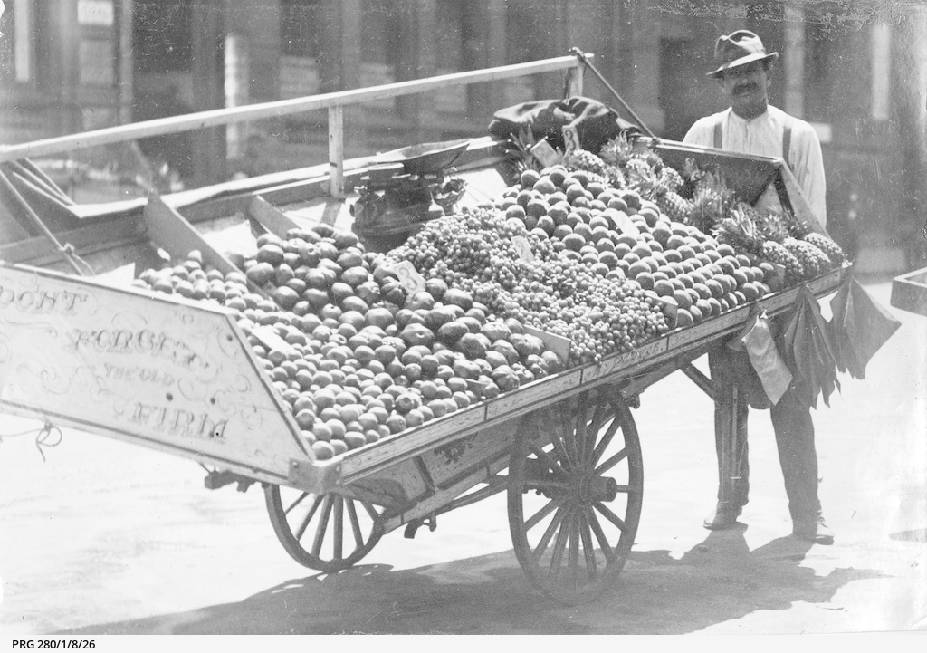 A vendor with his fruit and vegetable barrow stall Photograph